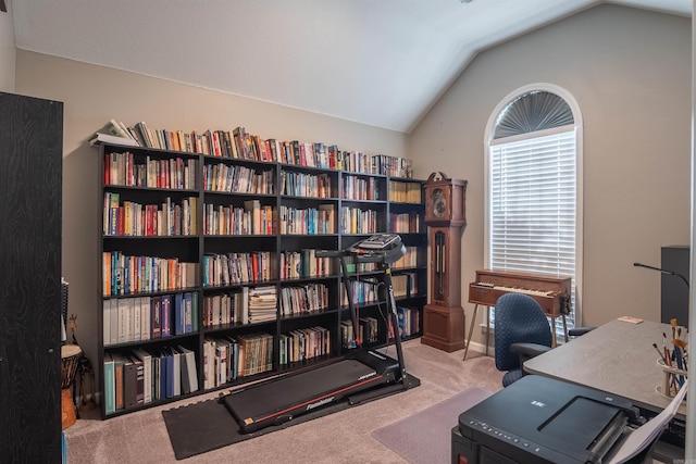 carpeted home office with lofted ceiling