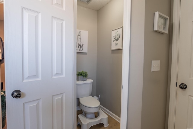 bathroom featuring visible vents, toilet, and baseboards