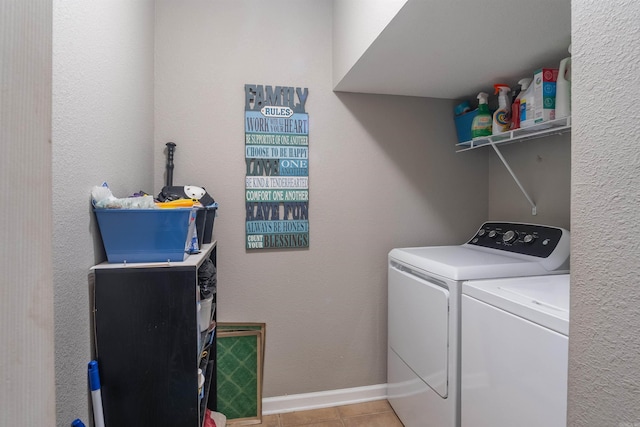 laundry room with washer and dryer, laundry area, light tile patterned flooring, and baseboards