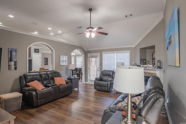 living area with wood finished floors, visible vents, lofted ceiling, arched walkways, and ceiling fan