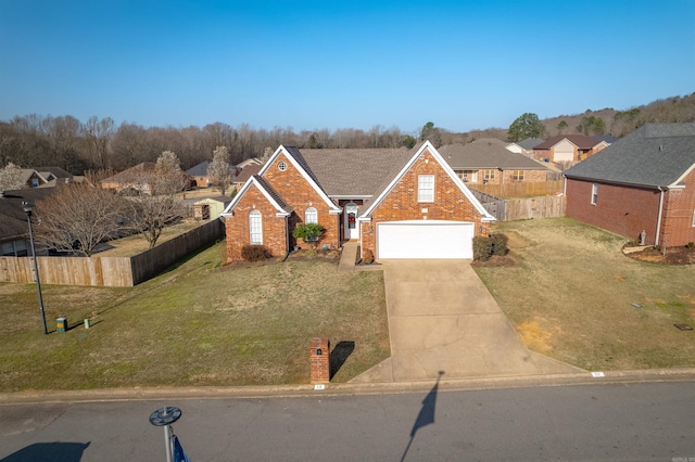 traditional-style home with brick siding, concrete driveway, fence, and a front yard