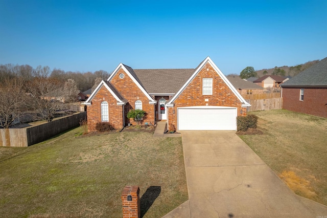 traditional home featuring a front lawn, fence, brick siding, and driveway