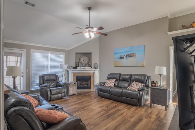 living area with visible vents, wood finished floors, ceiling fan, and a tile fireplace