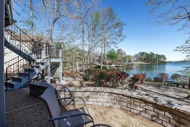 view of patio / terrace featuring stairway and a water view