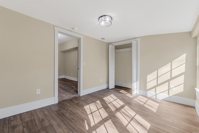 unfurnished bedroom featuring a closet, baseboards, and wood finished floors