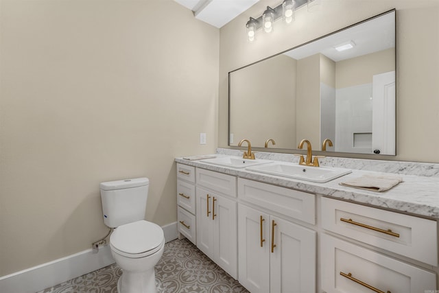 full bath with a sink, baseboards, toilet, and double vanity