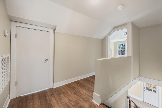 interior space with ceiling fan, baseboards, lofted ceiling, and wood finished floors