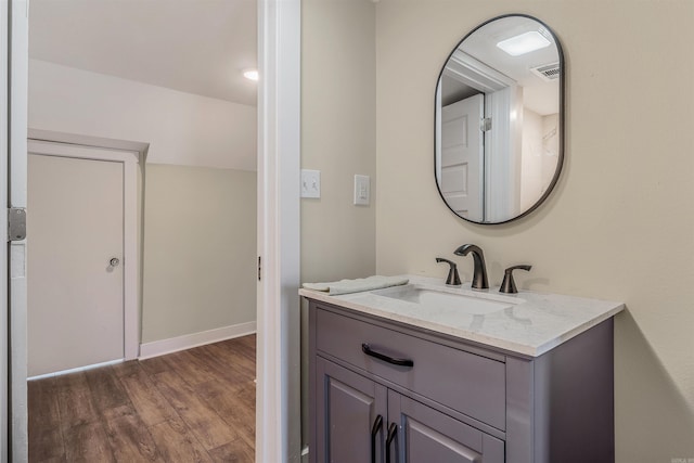 bathroom featuring vanity, visible vents, wood finished floors, and baseboards