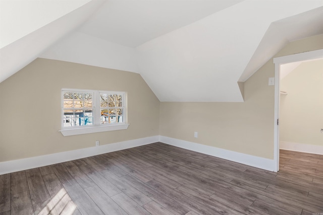 bonus room with vaulted ceiling, wood finished floors, and baseboards