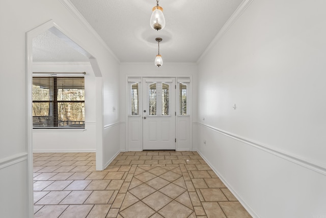 foyer featuring a wealth of natural light, a textured ceiling, light tile patterned flooring, and crown molding