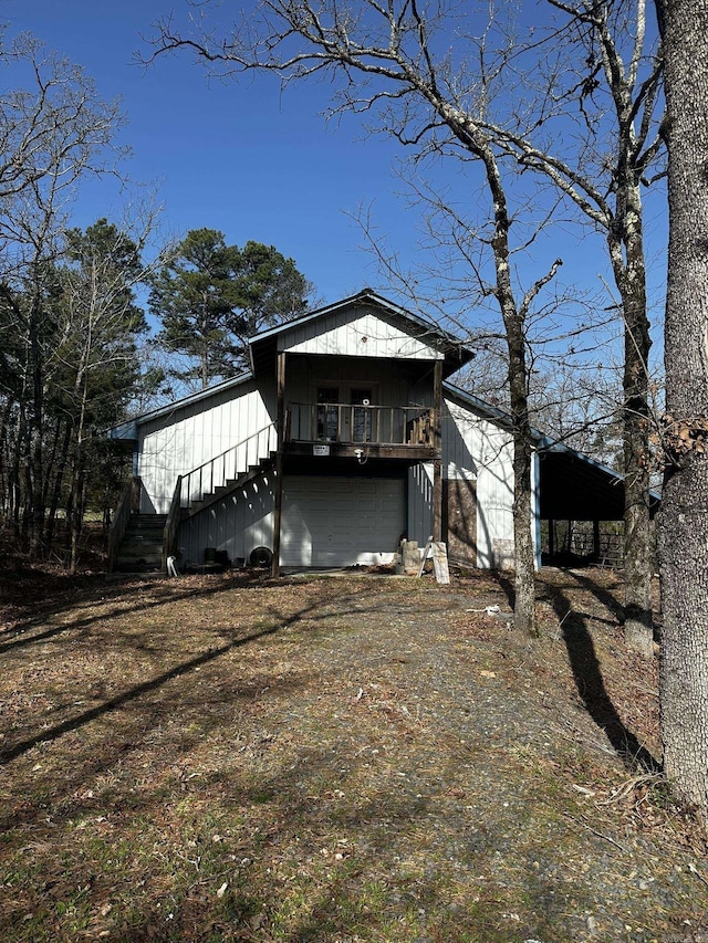 view of front of property featuring an attached garage and dirt driveway