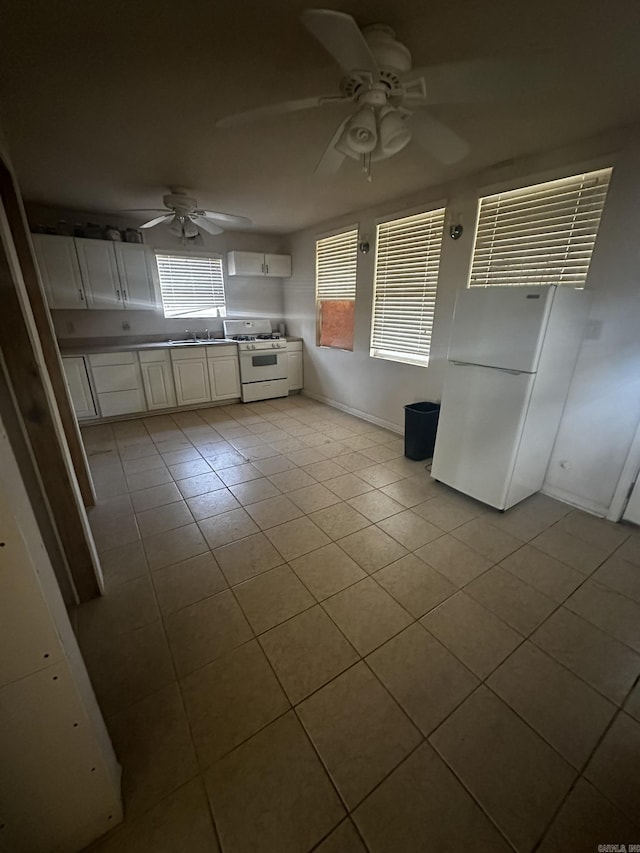 kitchen with tile patterned flooring, baseboards, white cabinets, white appliances, and a ceiling fan