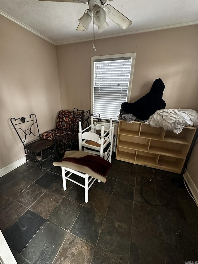 interior space with baseboards, ornamental molding, and a ceiling fan