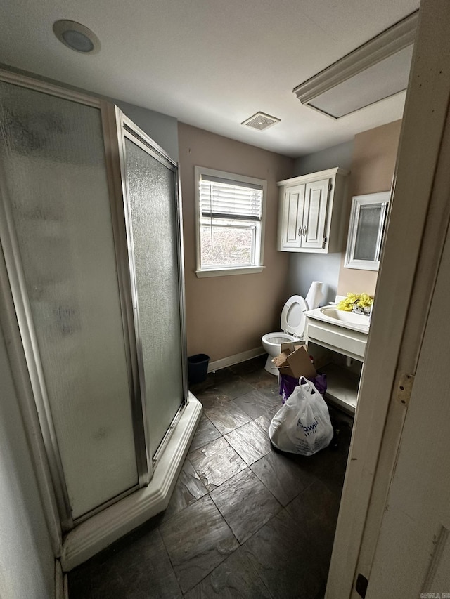 bathroom with visible vents, baseboards, toilet, a stall shower, and vanity