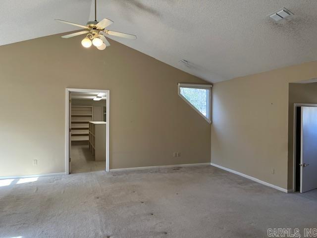 unfurnished bedroom featuring visible vents, a textured ceiling, carpet flooring, and vaulted ceiling