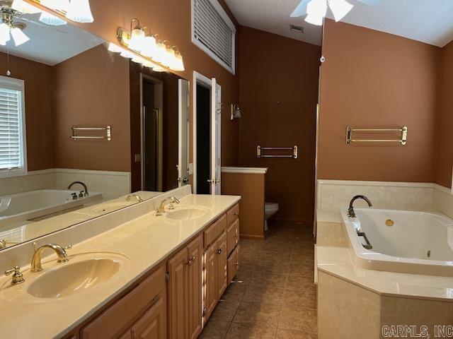 full bath with tile patterned flooring, a ceiling fan, and a sink