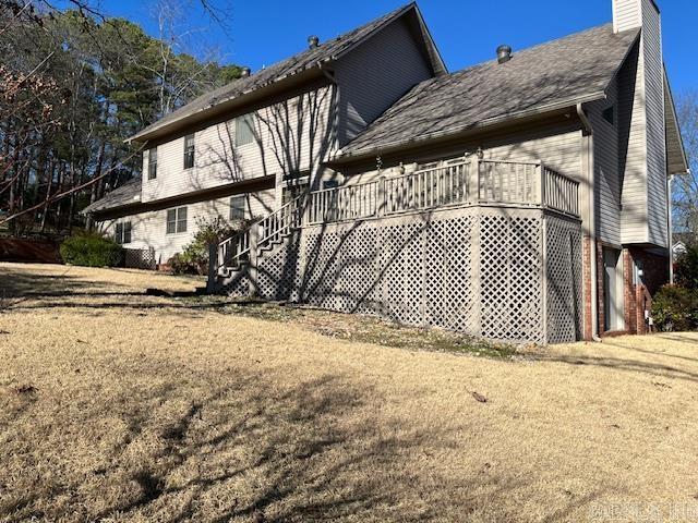 rear view of property with a wooden deck and a chimney