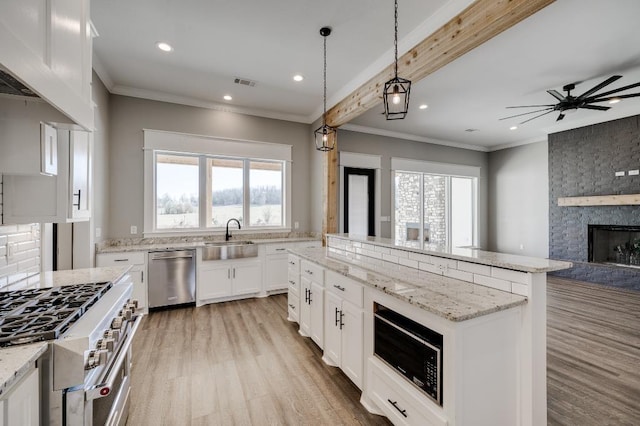 kitchen featuring visible vents, a sink, black microwave, stainless steel dishwasher, and a center island