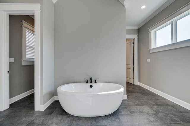 bathroom featuring recessed lighting, a freestanding tub, baseboards, and ornamental molding