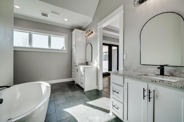 full bathroom with a soaking tub, two vanities, visible vents, and a sink