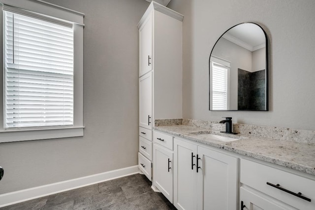 bathroom featuring baseboards, vanity, and crown molding