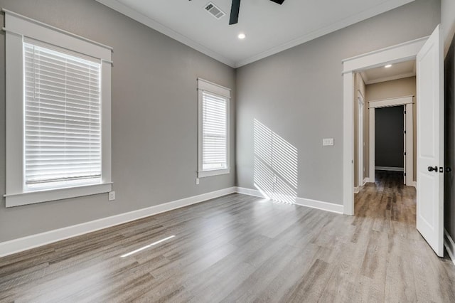 spare room with ceiling fan, visible vents, baseboards, and ornamental molding