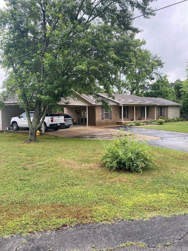 ranch-style home with an attached carport, driveway, and a front yard