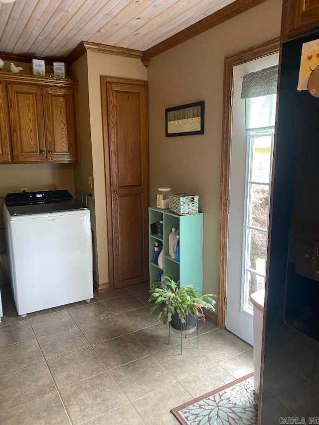 laundry room featuring ornamental molding, washer / clothes dryer, cabinet space, light tile patterned floors, and wood ceiling