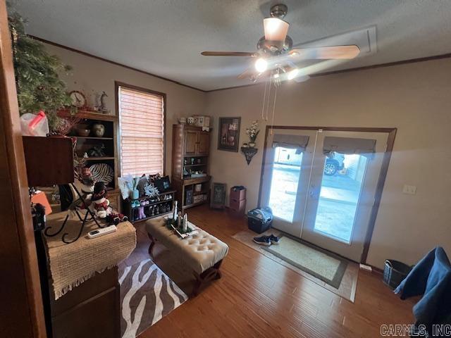 living area featuring a healthy amount of sunlight, french doors, ceiling fan, and wood finished floors