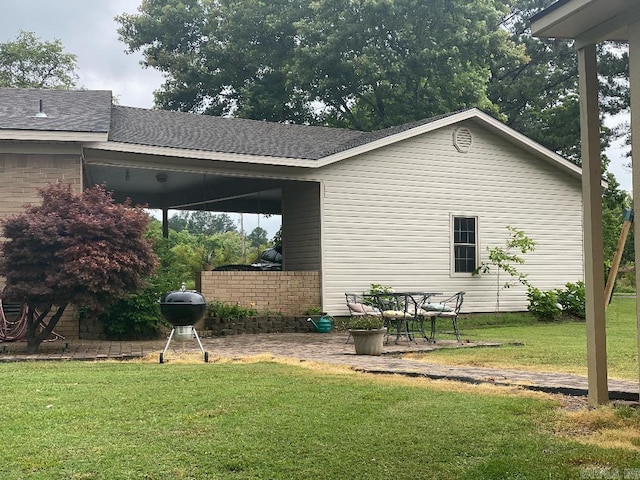 view of side of home featuring a patio and a yard