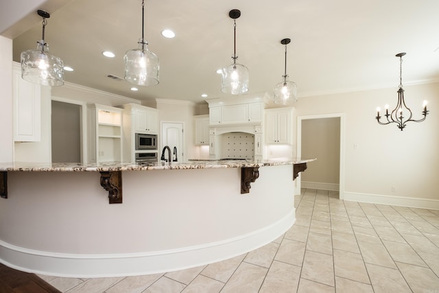 kitchen featuring stainless steel appliances, light stone countertops, a kitchen bar, and ornamental molding