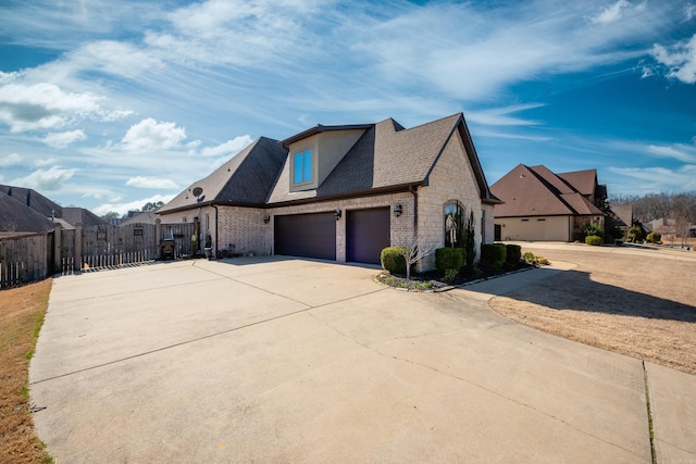 view of front facade with brick siding, fence, concrete driveway, stone siding, and a gate