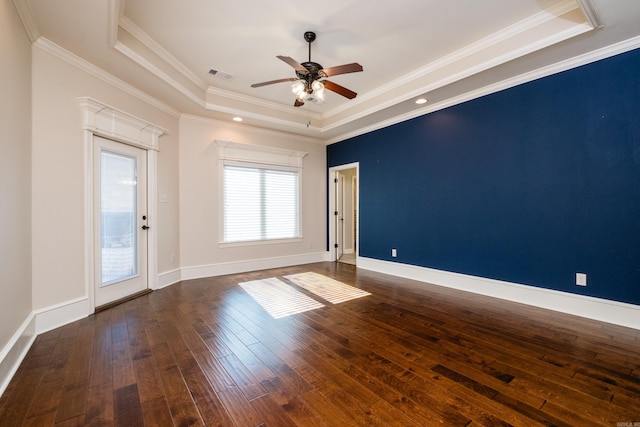 unfurnished room with visible vents, ceiling fan, baseboards, dark wood finished floors, and a tray ceiling