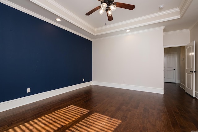 empty room with baseboards, a tray ceiling, a ceiling fan, and wood-type flooring