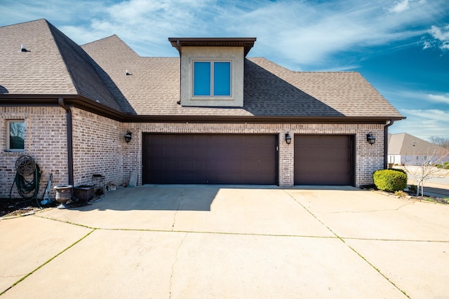 view of front of home featuring a garage, brick siding, roof with shingles, and driveway