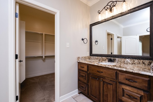 bathroom with vanity, crown molding, and baseboards