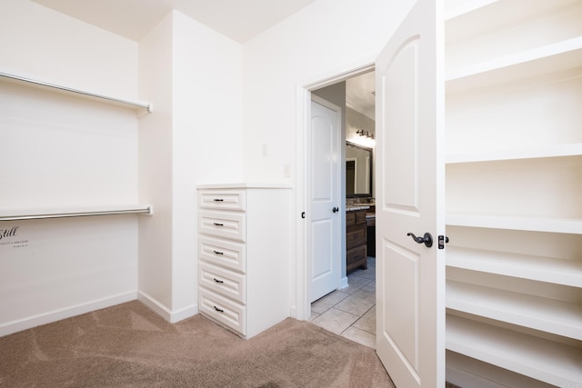 walk in closet featuring light colored carpet