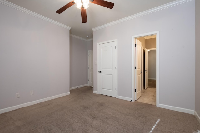 unfurnished bedroom with a ceiling fan, crown molding, carpet, and baseboards