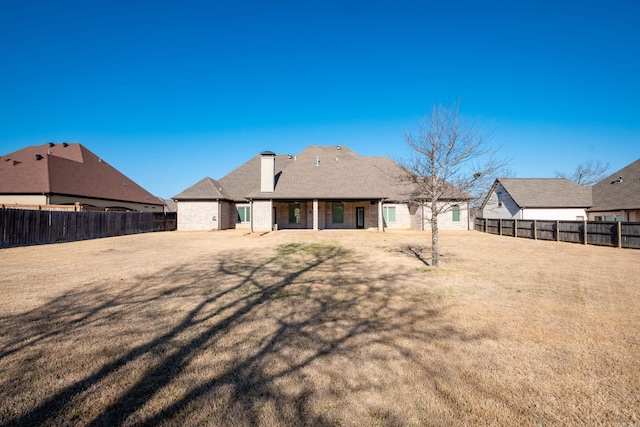 back of property with a yard and a fenced backyard