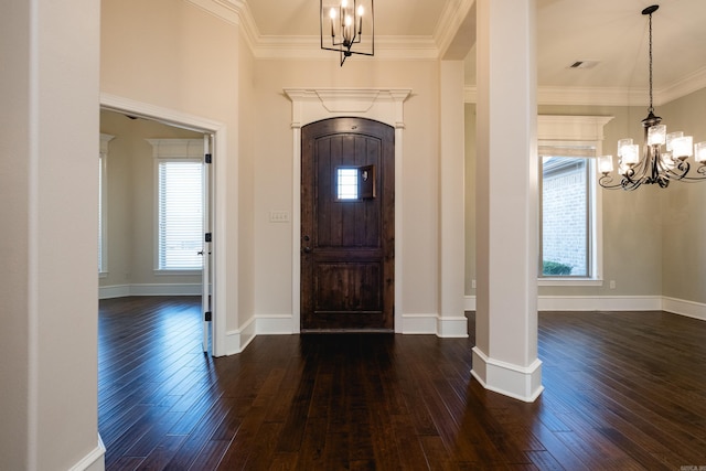 foyer with dark wood finished floors, an inviting chandelier, and ornamental molding