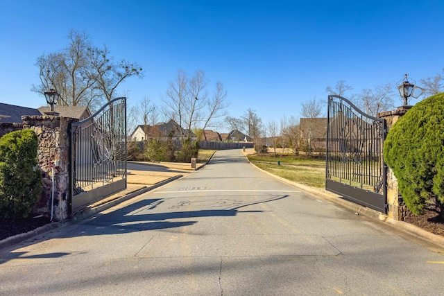 view of street featuring curbs, a gated entry, and a gate