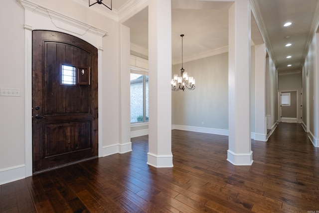 foyer with hardwood / wood-style floors, crown molding, baseboards, and a chandelier