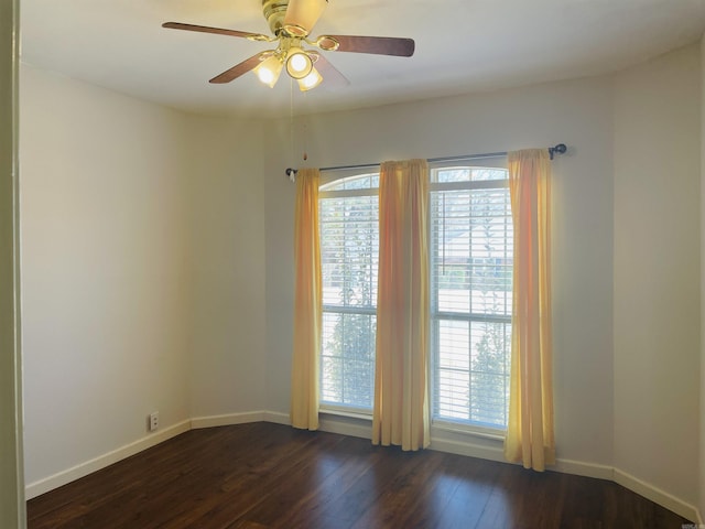 spare room with ceiling fan, baseboards, and dark wood-style flooring