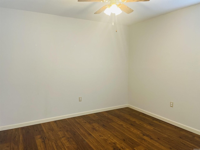 unfurnished room featuring baseboards, dark wood-style floors, and a ceiling fan