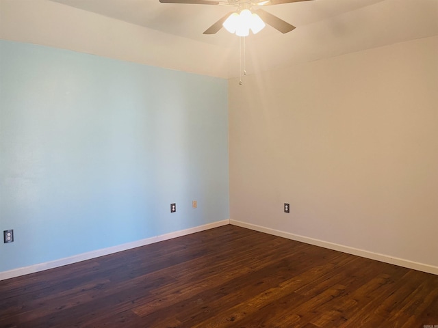 empty room featuring dark wood finished floors, a ceiling fan, and baseboards