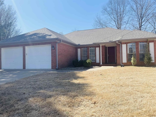 ranch-style home with roof with shingles, concrete driveway, a front yard, an attached garage, and brick siding