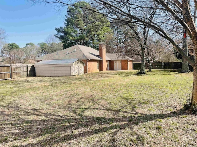 view of yard with a shed, an outdoor structure, and a fenced backyard