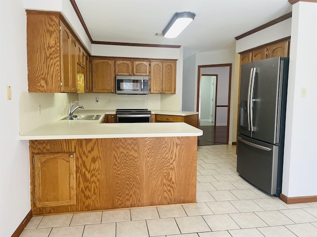 kitchen with a peninsula, a sink, ornamental molding, light countertops, and stainless steel appliances