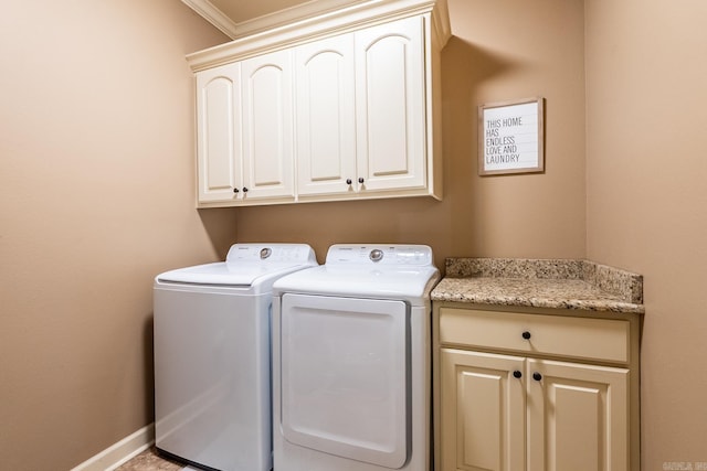 washroom with baseboards, cabinet space, and washing machine and clothes dryer