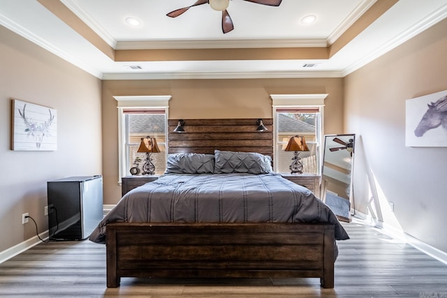 bedroom with visible vents, a raised ceiling, and crown molding